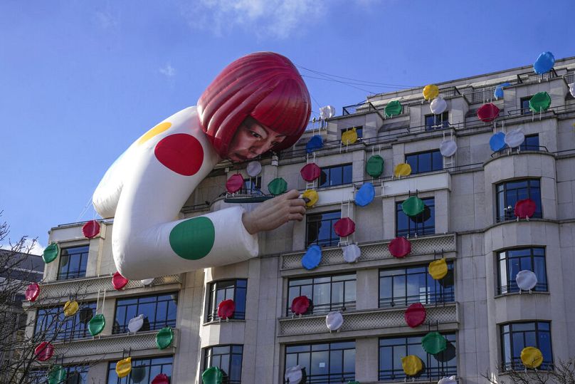 The installation of Japanese artist Yayoi Kusama, peering over the Louis Vuitton flagship store is pictured at the Champs Elysees avenue in Paris, Sunday, Jan. 15, 2023.