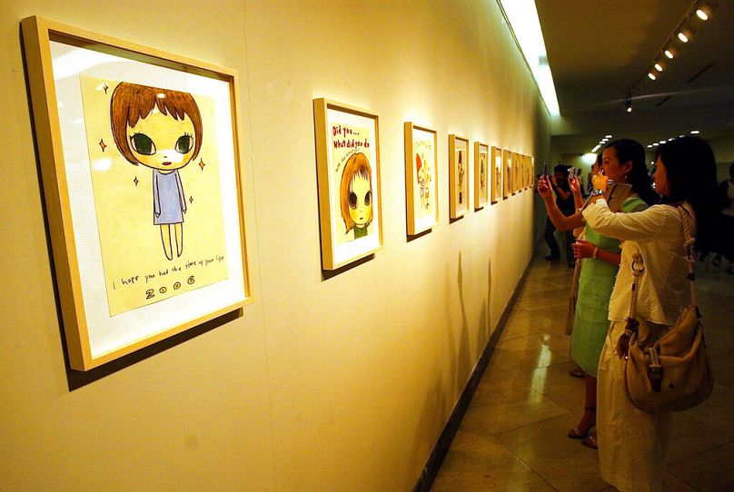 Guests look at pieces of work of Japanese artist Yoshitomo Nara at the pre-opening day of the 6th Shanghai Biennial on 5 September 2006 in Shanghai, China.