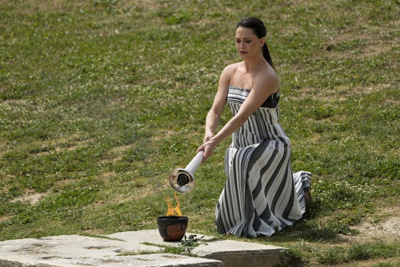 Baş rahibeyi canlandıran oyuncu Mary Mina, Antik Olympia alanında Paris Olimpiyatları için resmi töreni sırasında bir gün önce yakılan ateşle meşaleyi tutuşturdu