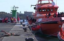 Migrants disembark a coastguard ship in Lanzarote