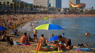 İspanya'nın Barselona kentindeki Barceloneta Plajı'nda güneşin tadını çıkaran vatandaşlar