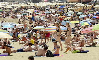 İspanya'nın Barselona kentindeki Barceloneta plajında güneşin tadını çıkaran vatandaşlar