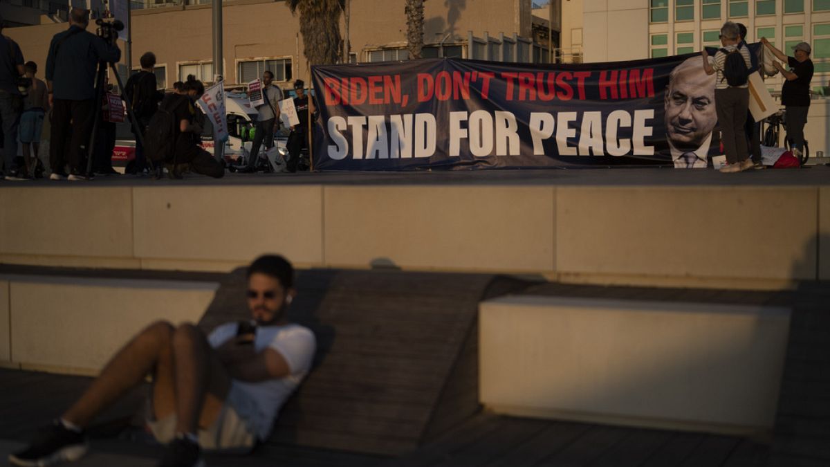 أشخاص يحملون لافتة تشير إلى الرئيس الأمريكي جو بايدن بعدم الثقة في رئيس الوزراء الإسرائيلي بنيامين نتنياهو