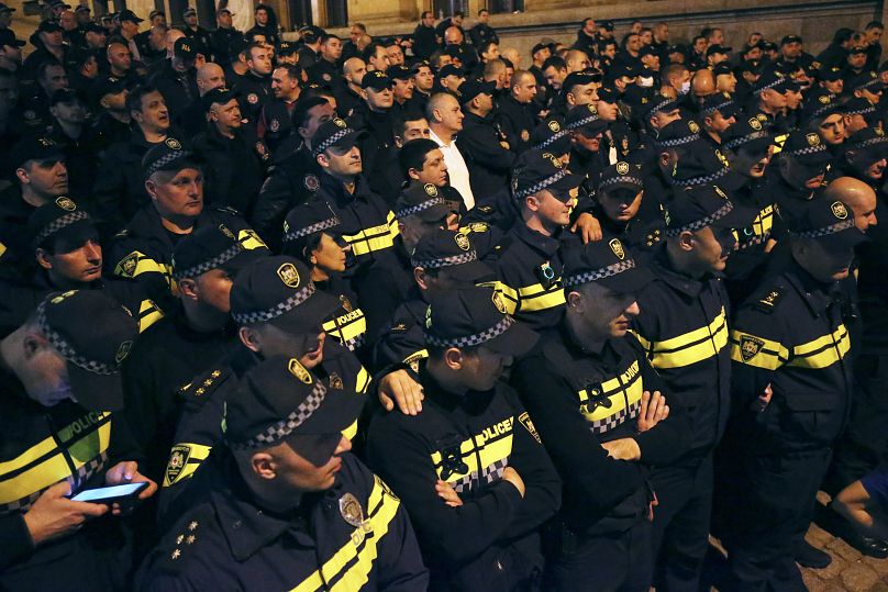 Police officers block protestors as they gather outside the parliament building in Tbilisi, Georgia, on Tuesday, April 16, 2024