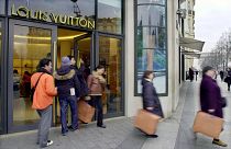 Shoppers leave the Champs Elysees Louis Vuitton shop in Paris 