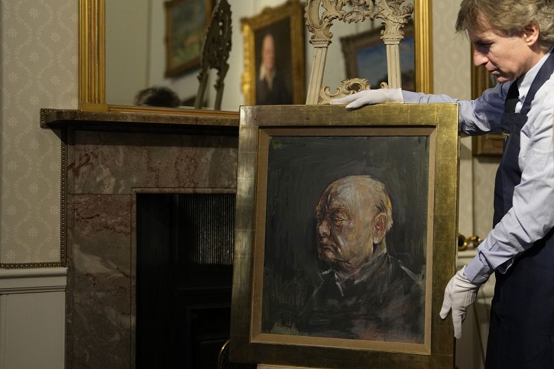 A member of staff from Sotheby's poses for the media with a portrait of the iconic former British Prime Minister Winston Churchill, painted by Graham Sutherland in 1954