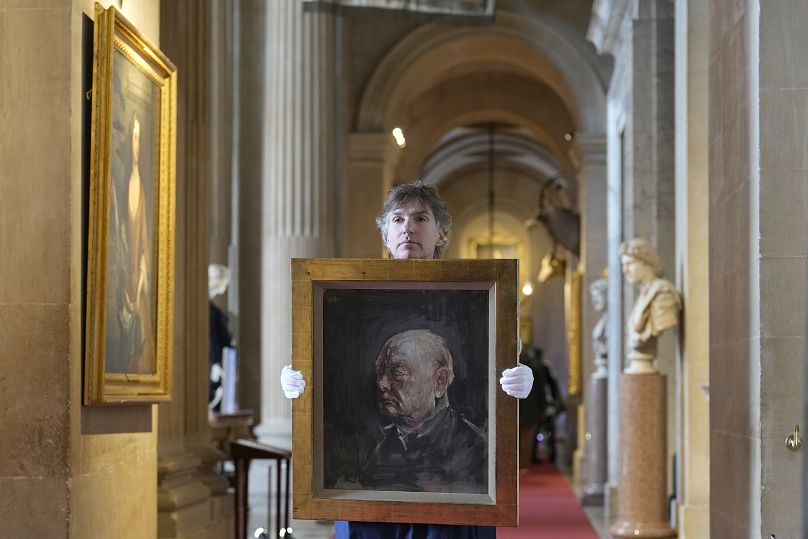 A member of staff from Sotheby's poses with the portrait