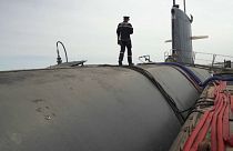 A crewman walks along the top of one of France's Rubis-class submarines