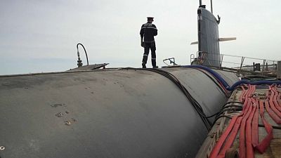 Um tripulante caminha ao longo do topo de um dos submarinos franceses da classe Rubis