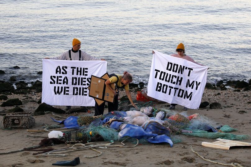 Activistas de Ocean Rebellion realizan una performance, en la orilla del río Tajo en Lisboa, el lunes 27 de junio de 2022.