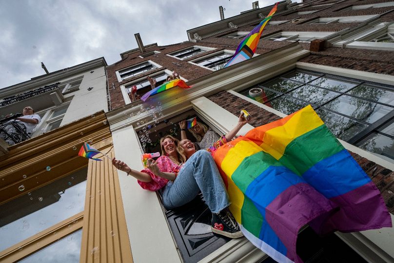 People watch dozens of colourfully-decorated boats touring the Dutch capital's historic canals Saturday in the most popular event of a six-day Pride Amsterdam festival