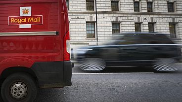 A car overtakes a Royal Mail delivery van, in Westminster in London, Thursday, Jan. 25, 2024.