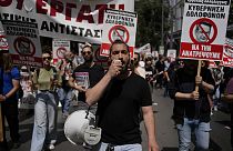 Protesters hold banners during a rally in Athens, Greece, Wednesday, April 17, 2024.