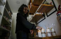 Una mujer enciende velas en su tienda después de un corte de energía programado ordenado por el Ministerio de Energía, en Quito, Ecuador, el martes 16 de abril de 2024.