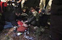 Tüntetők próbálnak segíteni egy eszméletlen társukon a tbiliszi tüntetésen