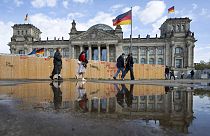 Passers-by walk past the Reichstag building in Berlin Friday, April 5, 2024. 