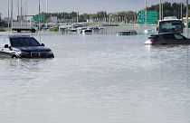 Verlassene Fahrzeuge auf einer überfluteten Straße in Dubai, Vereinigte Arabische Emirate.