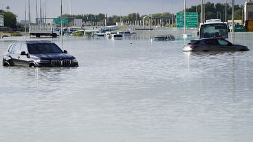 Vehicles sit abandoned in floodwaters covering a road in Dubai, United Arab Emirates.