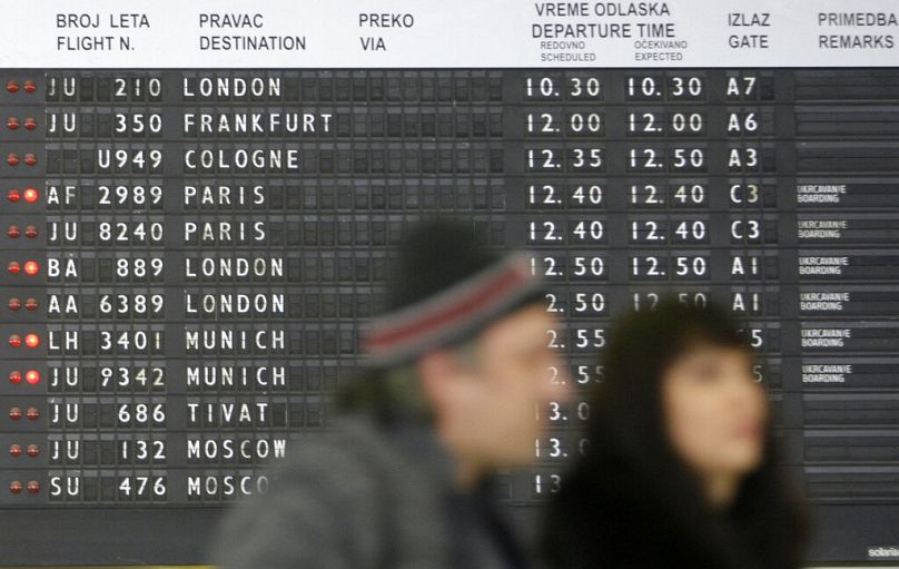 Passengers pass by the timetable at the airport Nikola Tesla, in Belgrade, December 2009