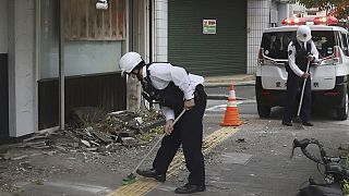 Police officers clean the debris from an earthquake in Uwajima, Ehime prefecture, western Japan 