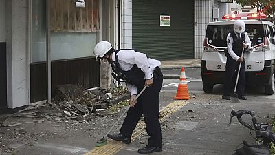 Police officers clean the debris from an earthquake in Uwajima, Ehime prefecture, western Japan 