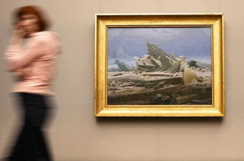 A woman walks near Caspar David Friedrich's painting 'The Sea of Ice' during a press preview