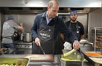 El príncipe William ayuda a preparar una salsa boloñesa durante una visita a Surplus to Supper, en Sunbury-on-Thames, Surrey, Inglaterra, el 18 de abril de 2024.