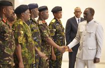 El presidente William Ruto estrecha la mano de altos funcionarios militares de Kenia, después de su discurso presidencial sobre la muerte del jefe militar del país