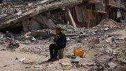 فلسطيني يجلس وسط الدمار الذي خلفه هجوم جوي وبري إسرائيلي على خان يونس، قطاع غزة، الإثنين، 8 أبريل/نيسان 2024.
