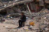 فلسطيني يجلس وسط الدمار الذي خلفه هجوم جوي وبري إسرائيلي على خان يونس، قطاع غزة، الإثنين، 8 أبريل/نيسان 2024.