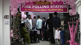 Menschen warten in einem rosa Wahllokal, in dem alle Wahlhelfer Frauen sind, um ihre Stimme abzugeben
