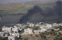El humo llena el cielo después de que colonos israelíes prendieran fuego a las propiedades de aldeanos palestinos en la localidad cisjordana de al-Mughayyir, sábado 13 de abril de 2024. 