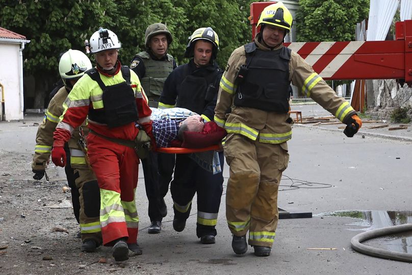 In this photo provided by the Ukrainian Emergency Service, rescuers and ambulance workers carry a person at the scene of a Russian attack in Dnipro, Ukraine, Friday, April 19.