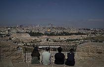 La gente visita el Monte de los Olivos con vistas a la Cúpula de la Roca en el recinto de la Mezquita de Al Aqsa en la Ciudad Vieja de Jerusalén, el 19 de abril de 2024.