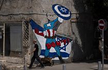 لوحة جدارية تصور الرئيس الأمريكي جو بايدن كبطل خارق يدافع عن إسرائيل في أحد شوارع تل أبيب، إسرائيل.