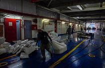 عمال إغاثة ينقلون المساعدات على متن سفينة أكدينيز التركية 
