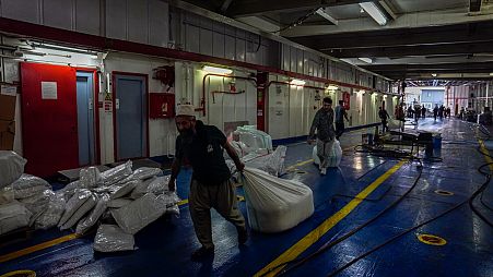 عمال إغاثة ينقلون المساعدات على متن سفينة أكدينيز التركية 
