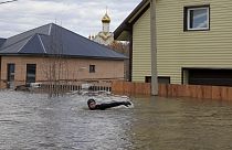Ein Anwohner schwimmt in der überfluteten Straße zwischen Häusern in Orenburg, 13. April 2024