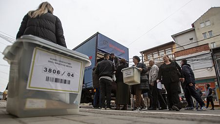 Kosovo election officials carry the ballot boxes and polling station materials in North Mitrovica, Kosovo 