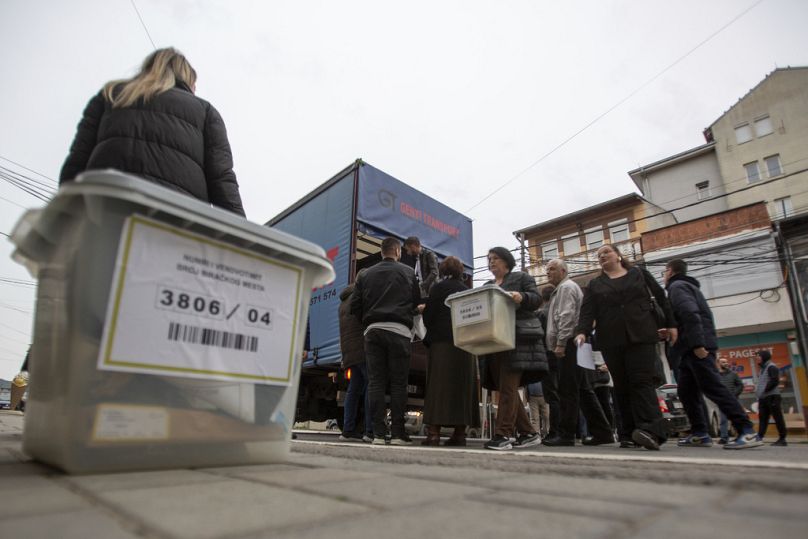 Kosovo election officials unload the ballot boxes and polling station materials in North Mitrovica, Kosovo