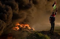 فلسطينيون يحرقون الإطارات ويلوحون بالعلم خلال احتجاج على الغارة العسكرية الإسرائيلية في مدينة جنين بالضفة الغربية قي 26 يناير 2023