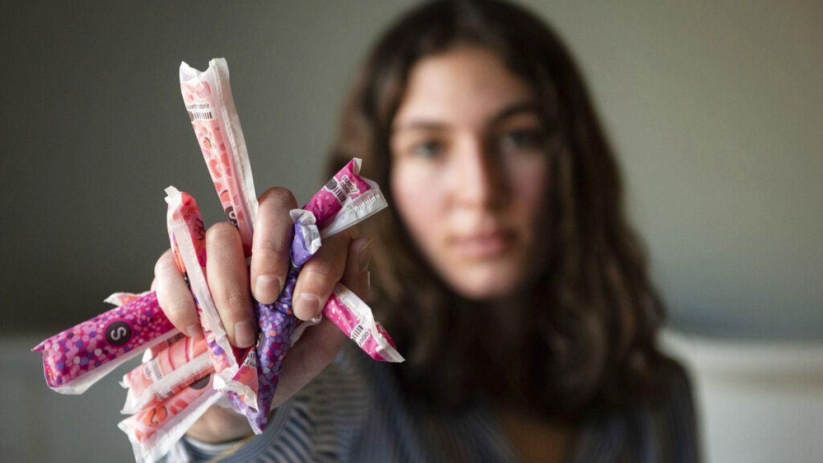 Sarina Horner, a 17-year-old senior at Forsyth Country Day School, holds a fistful of tampons as she sits for a portrait on her bed on Monday, Feb. 14, 2022, in Lewisville NC.