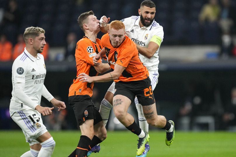 Real Madrid's Karim Benzema challenges with Shakhtar's Yukhym Konoplya during the Champions League group F at the Santiago Bernabeu stadium in Madrid, October 2022