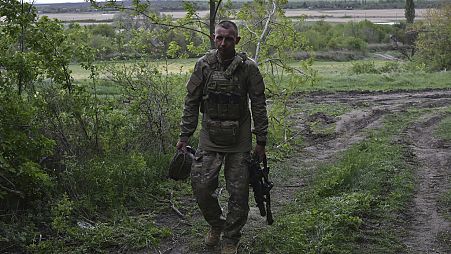A Ukrainian serviceman with the 65th Brigade walks to his armored vehicle at the frontline in Zaporizhzhia region, Ukraine, Sunday, April 21, 2024. 
