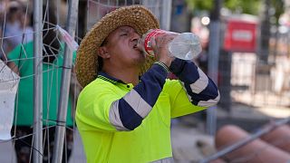 Un trabajador de la carretera se detiene a beber agua en Madrid, España.
