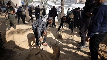 Palestinians dig graves to bury their relatives who were killed in the Israeli bombardment of the Gaza Strip, at the Nasser hospital in Khan Younis, Monday, Jan. 22, 2024.