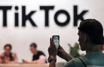 A visitor makes a photo at the TikTok exhibition stands at the Gamescom computer gaming fair in Cologne.