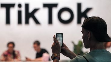 A visitor makes a photo at the TikTok exhibition stands at the Gamescom computer gaming fair in Cologne.