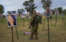 جندي إسرائيلي ينظر إلى صور الأشخاص الذين قتلوا يوم السابع من أكتوبر 