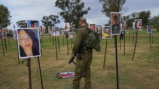 جندي إسرائيلي ينظر إلى صور الأشخاص الذين قتلوا يوم السابع من أكتوبر 